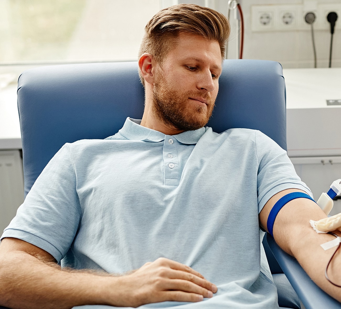 Man donating blood in a medical setting.