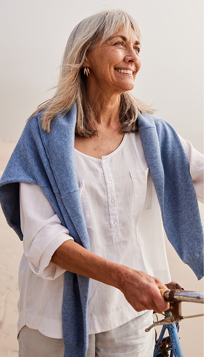 Smiling woman with gray hair at the beach.
